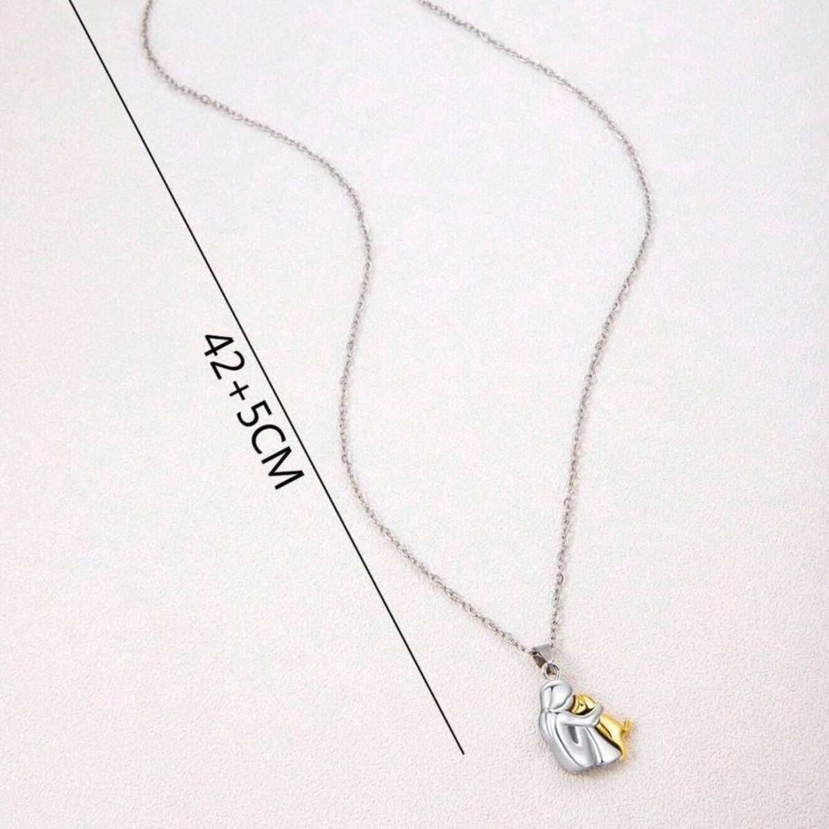 Srebrny naszyjnik z zawieszką w kształcie psa, symbolizujący obejmującego człowieka i psa, o biżuteryjnym wzornictwie | Hélène